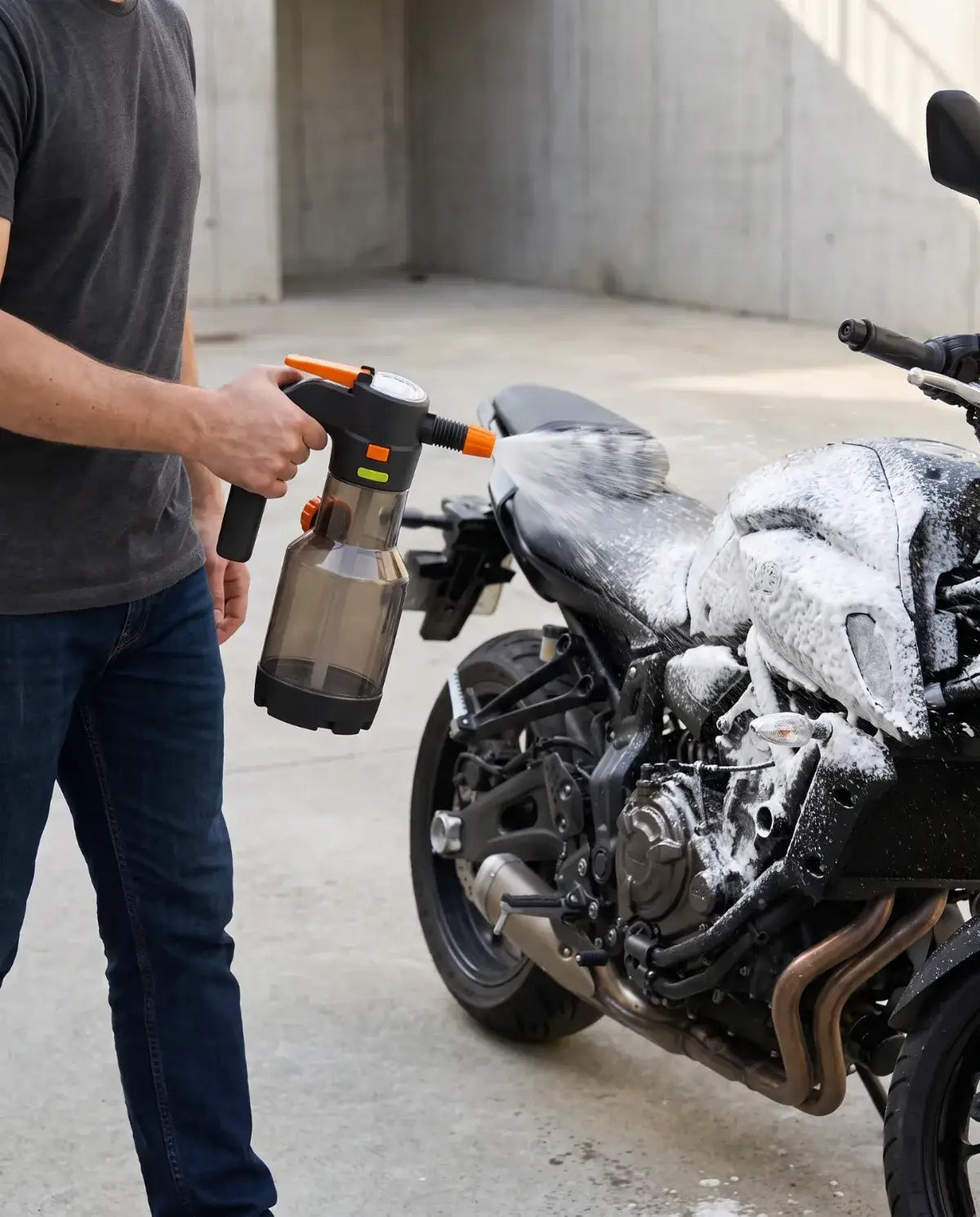 Pessoa caminha ao lado de uma moto aplicando espuma no tanque com o NÓRVO Foam 2L, sem cabo